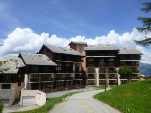 um grupo de edifícios de apartamentos numa estrada de terra batida em Appartement Peisey-Vallandry, 2 pièces, 5 personnes - FR-1-757-96 em Landry