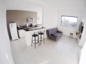 a kitchen and living room with a couch and a refrigerator at Condomínio Vista Nobre in Varginha