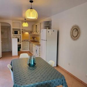 een keuken met een tafel en een witte koelkast bij Casa Marcelli 4 in Porto-Vecchio