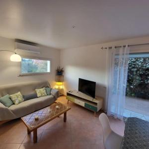 een woonkamer met een bank en een tv bij Casa Marcelli 4 in Porto-Vecchio