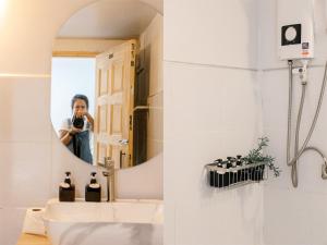 Eine Frau, die ein Bild von einem Badezimmerspiegel macht. in der Unterkunft Ikigawa Home in Ban Pha Khap + 37 Fotos