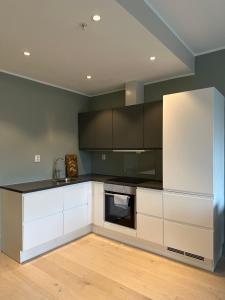 a kitchen with white cabinets and a black counter top at Penthouse, Lerkendal, NTNU, free parking in Trondheim