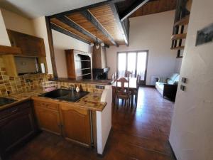 a kitchen with a sink and a living room at Le Colombera - Ideal pour sportif in Tende