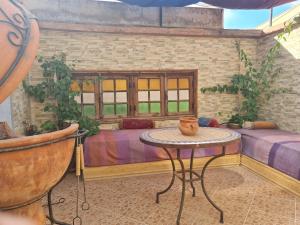 - un salon avec une table et un canapé dans l'établissement Riad BAB ALMADINA, à Marrakech