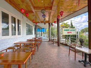 an empty restaurant with wooden tables and chairs at Cherry Luxury Villa in Xuan An