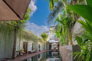 a courtyard with a swimming pool and plants at Victoria Central Residence in Siem Reap