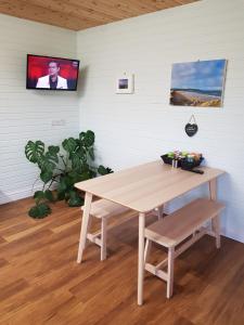 einen Tisch in einem Zimmer mit einem TV an der Wand in der Unterkunft Crag Na Cor Log Cabin in Culdaff