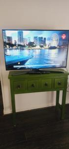 a flat screen tv sitting on top of a green table at Departamento 2d1b Puerto Varas in Puerto Varas