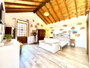 a living room with a white couch and wooden ceilings at Rural house with private pool, BBQ, and views of the Atlantic Ocean in Tenerife South in San Miguel de Abona