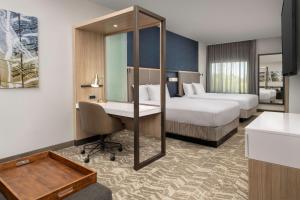 梅森SpringHill Suites by Marriott Cincinnati Mason的有两张床和一张书桌的酒店房间