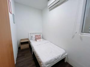 een kleine witte kamer met een klein bed erin bij Penang Heritage Home in George Town