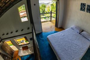 a bedroom with a bed and a door to a balcony at Duplex Sol in Maresias