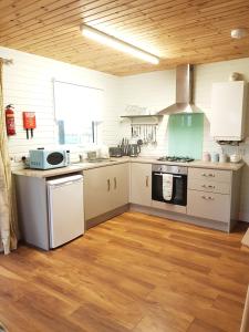 a kitchen with white cabinets and a stove top oven at Crag Na Cor Log Cabin in Culdaff