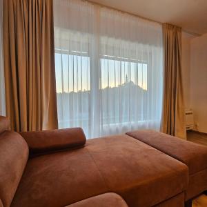 ニトラにあるApartmán PROMENÁDAのベッドルーム1室(山の景色を望む大きな窓付)
