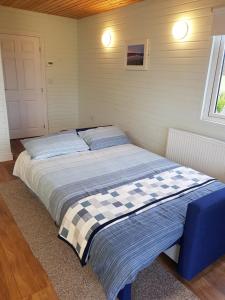 duże łóżko w pokoju z oknem w obiekcie Crag Na Cor Log Cabin w mieście Culdaff