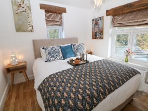 1 dormitorio con 1 cama grande y 2 ventanas en Toll Bar Cottage, en Bakewell