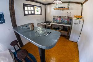 a small kitchen with a table and a refrigerator at Duplex Sol in Maresias
