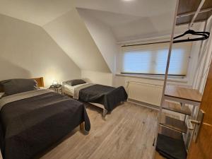 a attic bedroom with two beds and a window at Fewo mit Ausblick in Salzgitter