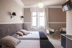 a hotel room with two beds and a window at AinB B&B Eixample-Muntaner in Barcelona