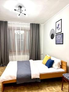 a bedroom with a large bed in front of a window at Квартира на Атакенте у Выставки in Almaty