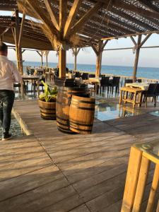 a man walking on a wooden deck near the beach at Villa Zeytin - Private Pool Villa in Vasilia