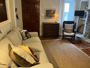 a living room with a couch and a chair at The Trinity Cottage in Manayunk, Walk to Main Street and Train in Philadelphia