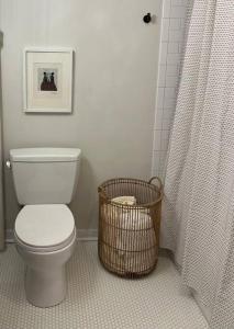 a bathroom with a toilet and a shower with a basket at The Trinity Cottage in Manayunk, Walk to Main Street and Train in Philadelphia