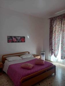 ein Schlafzimmer mit einem großen Bett mit einer lila Decke in der Unterkunft Vento di Scirocco in Pozzallo