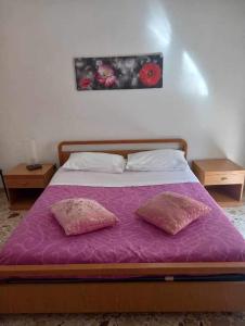 ein Schlafzimmer mit einem Bett mit zwei Kissen darauf in der Unterkunft Vento di Scirocco in Pozzallo