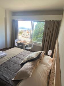 1 dormitorio con cama y ventana grande en Patagonia Center en San Carlos de Bariloche