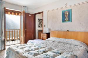 Casa paradiso di montagna في Roccaforte Mondovì: غرفة نوم بسرير كبير ونافذة