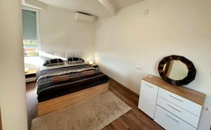 Schlafzimmer mit einem Bett und einem Wandspiegel in der Unterkunft Velvet Vista in Štip