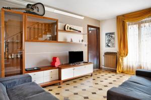 ein Wohnzimmer mit einem Sofa und einem TV in der Unterkunft Casa paradiso di montagna in Roccaforte Mondovì