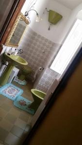 ein Badezimmer mit grünem WC und Waschbecken in der Unterkunft Casa San Francesco in Agnone