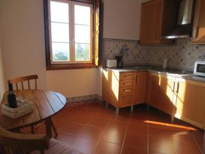辛特拉的住宿－Casa da Villa 1A，厨房配有桌子、桌子和窗户