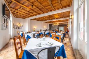 a dining room with blue tables and chairs at Hotel Monte Brasil in Angra do Heroísmo