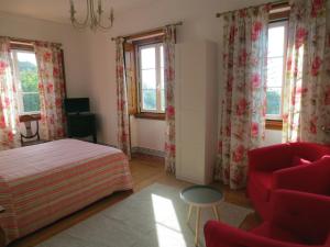辛特拉的住宿－Casa da Villa 1A，一间卧室配有一张床、一把椅子和窗户。