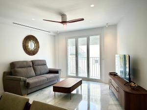 a living room with a couch and a ceiling fan at SMILE CAVANA APARTMENTS in Nerja