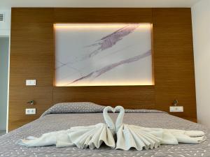 Un dormitorio con una cama con un cuadro en la pared. en SMILE CAVANA APARTMENTS, en Nerja