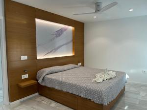 1 dormitorio con 1 cama y una pintura en la pared en SMILE CAVANA APARTMENTS, en Nerja