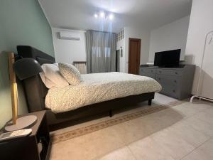 a bedroom with a bed and a dresser with a television at MIEDONNE home in Rome in Rome