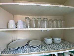 a shelf with glass jars and bowls on it at Lovely 2BR Home with Fireplace and Patio in Culver in Los Angeles