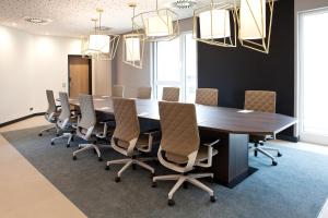 una sala de conferencias con una mesa grande y sillas en Hampton by Hilton Munich Airport South, en Hallbergmoos