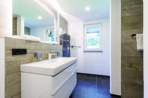 uma casa de banho branca com um lavatório e uma janela em Seeluft an der Ostsee em Wustrow