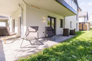 um pátio com duas cadeiras ao lado de uma casa em Seeluft an der Ostsee em Wustrow