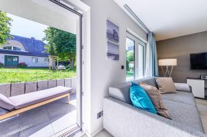 uma sala de estar com um sofá e uma porta de vidro deslizante em Seeluft an der Ostsee em Wustrow