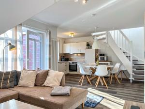 Una sala de estar y una cocina con un sofá y una mesa. en Haus am Teich Wohnung 19, en Boltenhagen