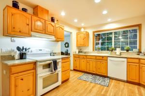 a kitchen with wooden cabinets and white appliances at Milwaukie Home with Covered Porch Dogs Welcome! in Milwaukie