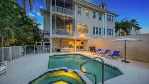 a house with a swimming pool in front of a house at The Key Canal - 455 in Siesta Key