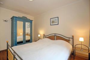 ein Schlafzimmer mit einem Bett mit einem blauen Schrank und einem Spiegel in der Unterkunft Ostseewelle Wohnung 08 in Kühlungsborn